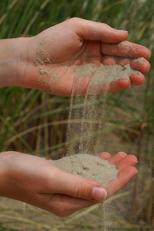 Hände spielen mit Sand